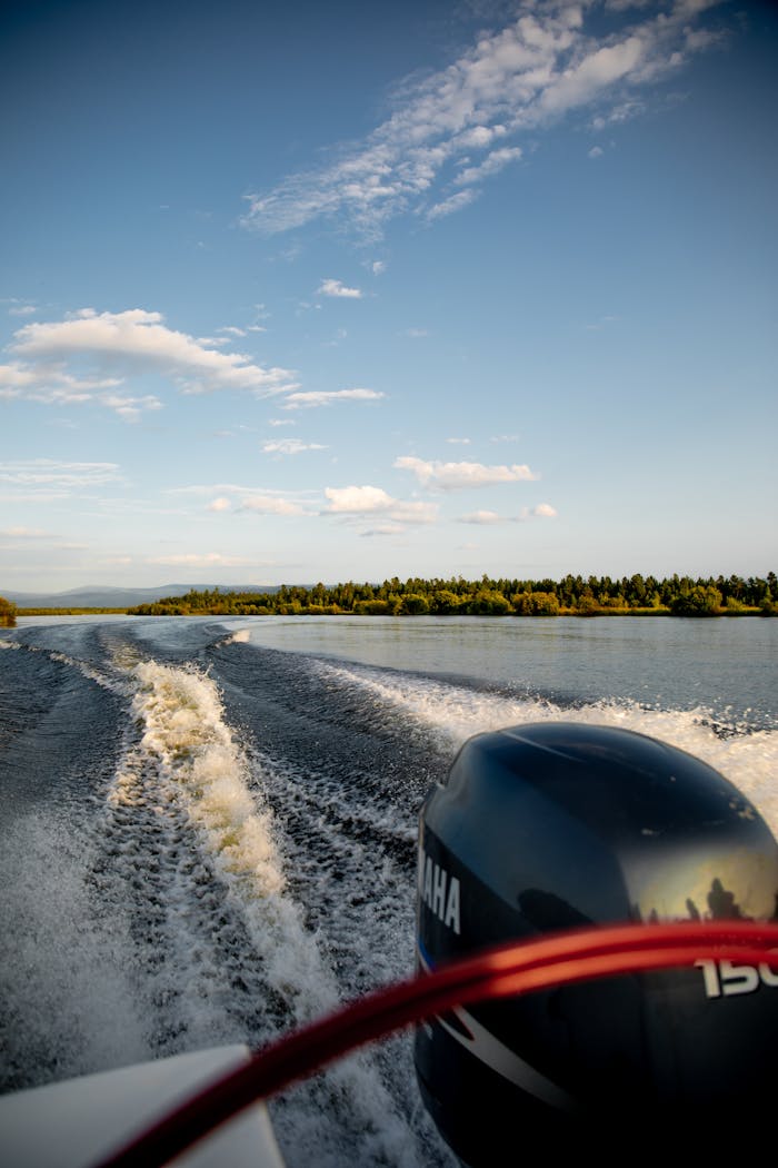 Captivating view from a speedboat with a Yamaha motor slicing through a scenic lake under a clear blue sky.